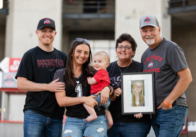 The Forshey-Oliphant family holding a picture of Lu in front of Ohio Stadium