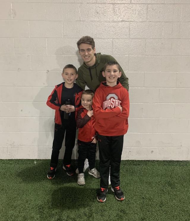 Pax with his brothers, Pace and Pierce, and Derek, a member of the Family Relations committee during a Buckeye Buddies event.